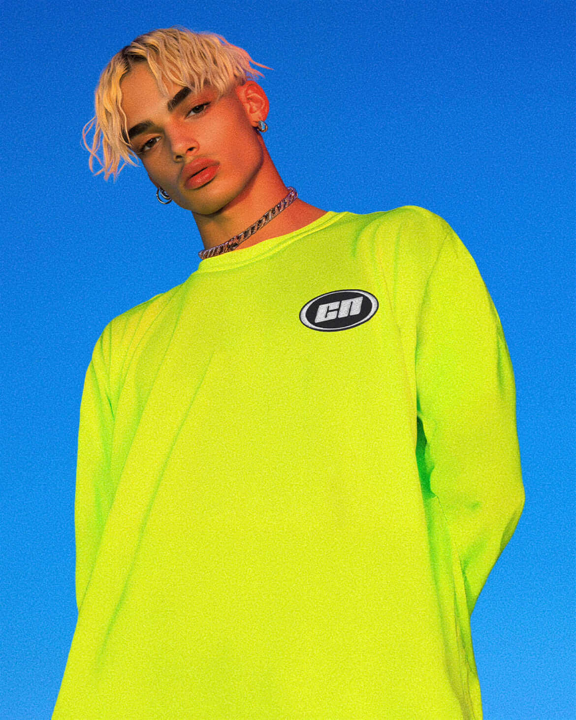 Model wearing a neon lime long sleeve cotton t-shirt with embroidered Club Neo logo against a blue background.