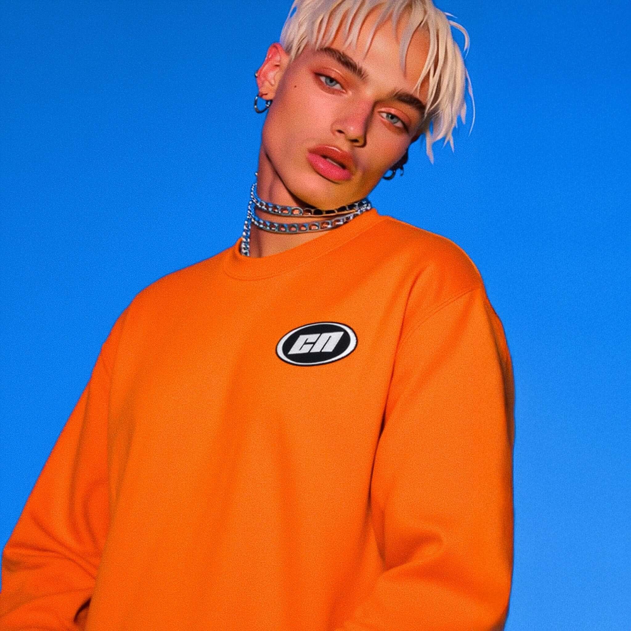 Person wearing an orange sweatshirt with a logo against a blue background
