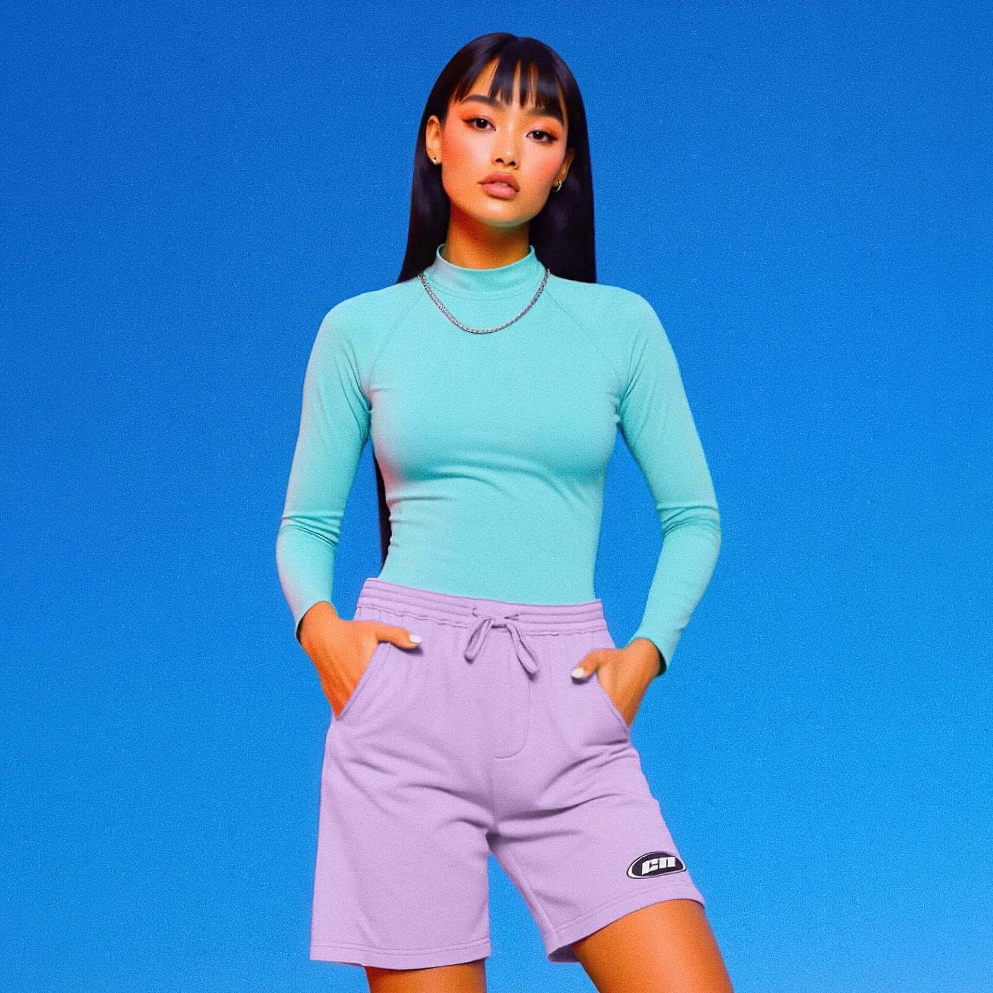Woman wearing a turquoise long-sleeve top and purple shorts against a blue background