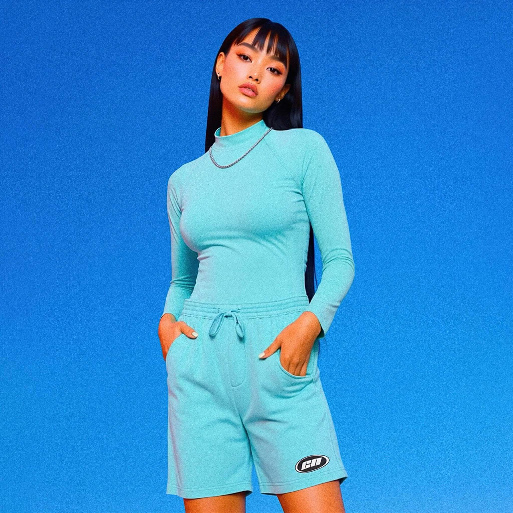 Woman wearing a matching turquoise outfit with a brand logo on a blue background