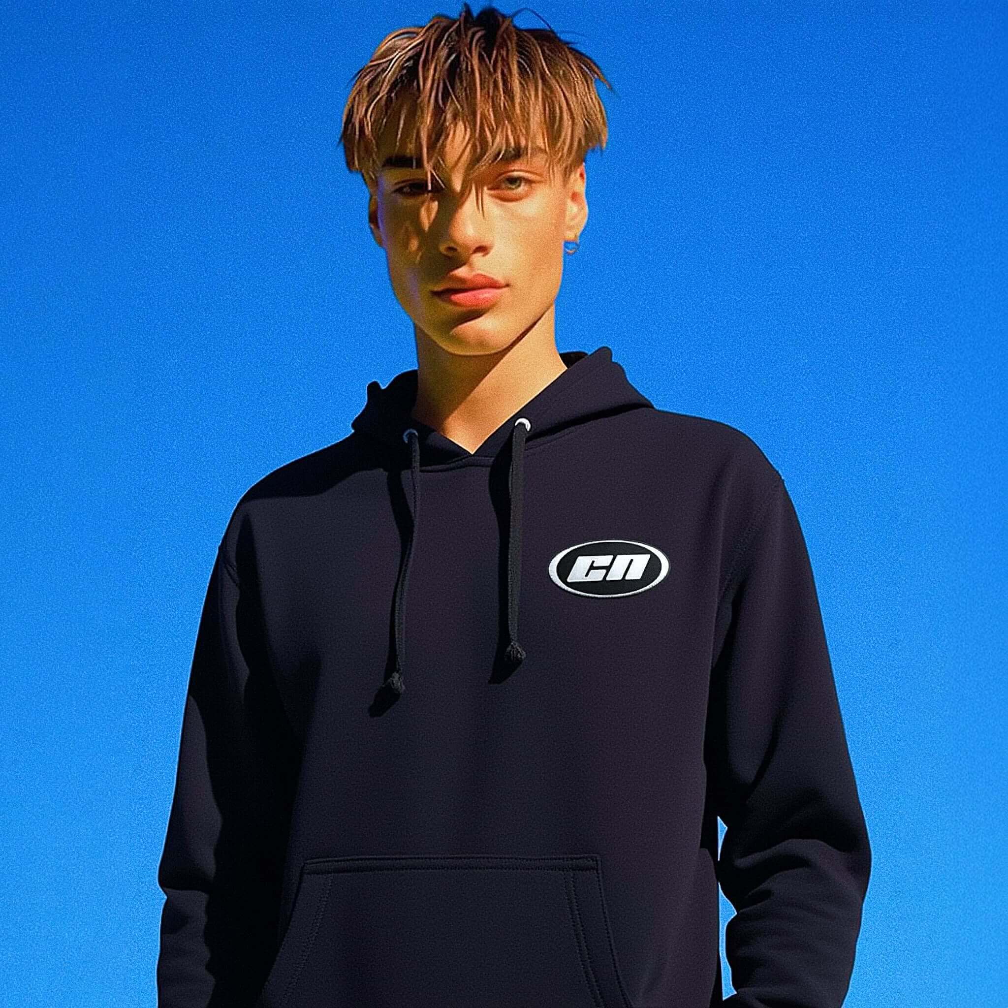 Person wearing a black hoodie with a logo against a blue sky
