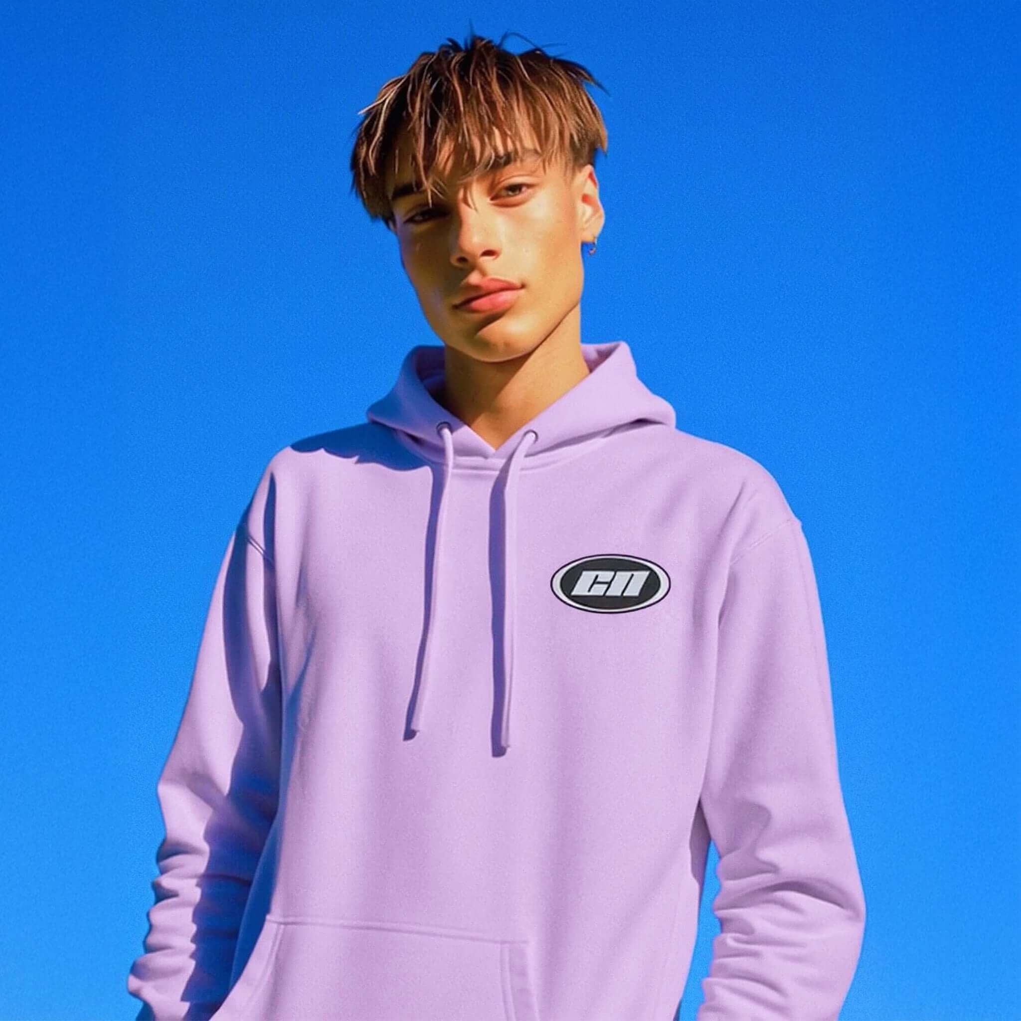 Person wearing a light purple hoodie with a logo against a clear blue sky