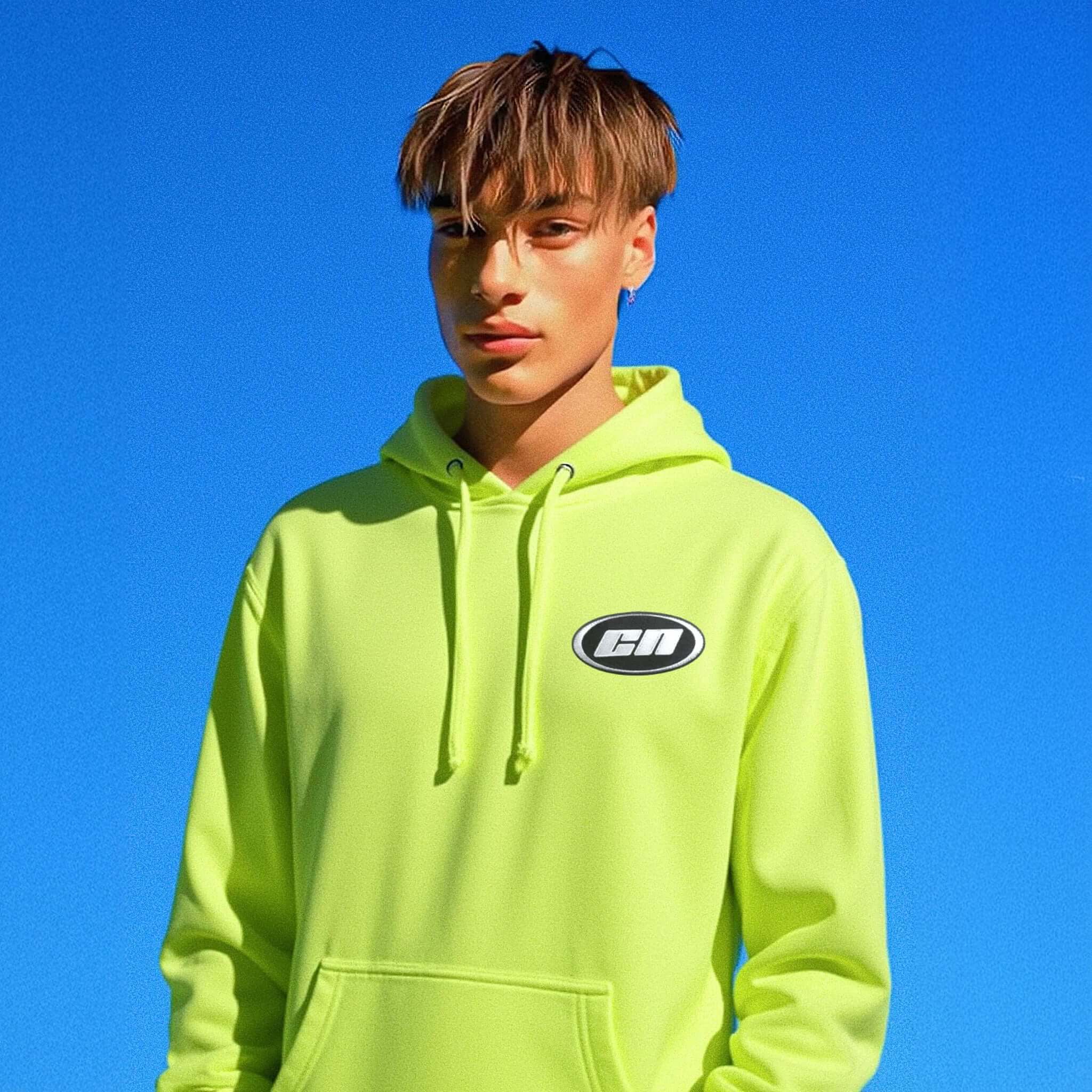 Person wearing a bright green hoodie with a logo against a clear blue sky