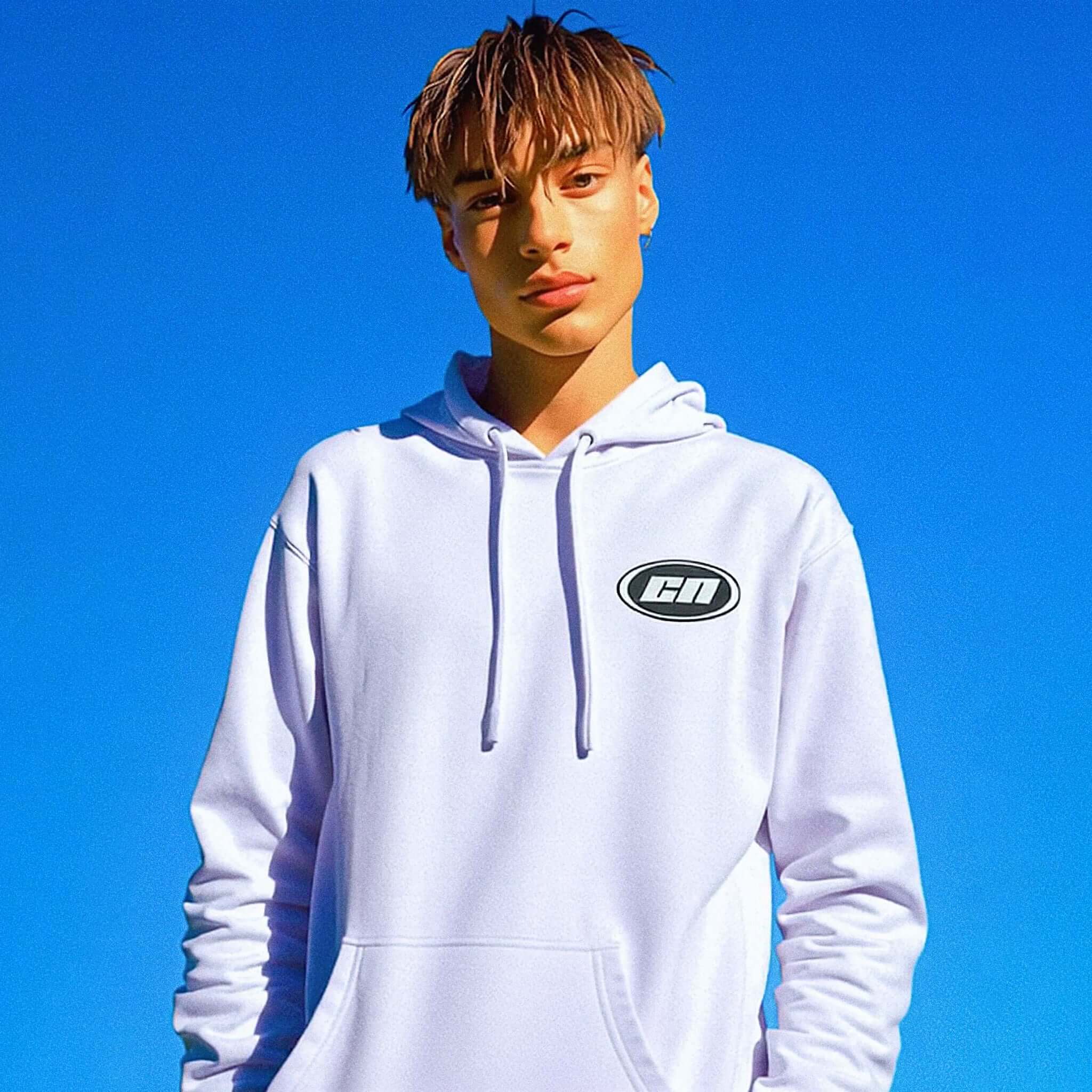 Person wearing a white hoodie with a logo against a clear blue sky